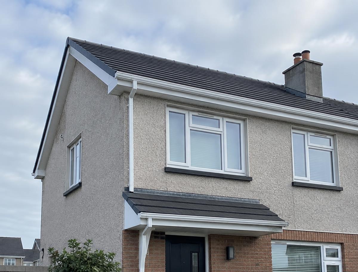 Two-storey house roofline with tidy verge edges and guttering after repair work
